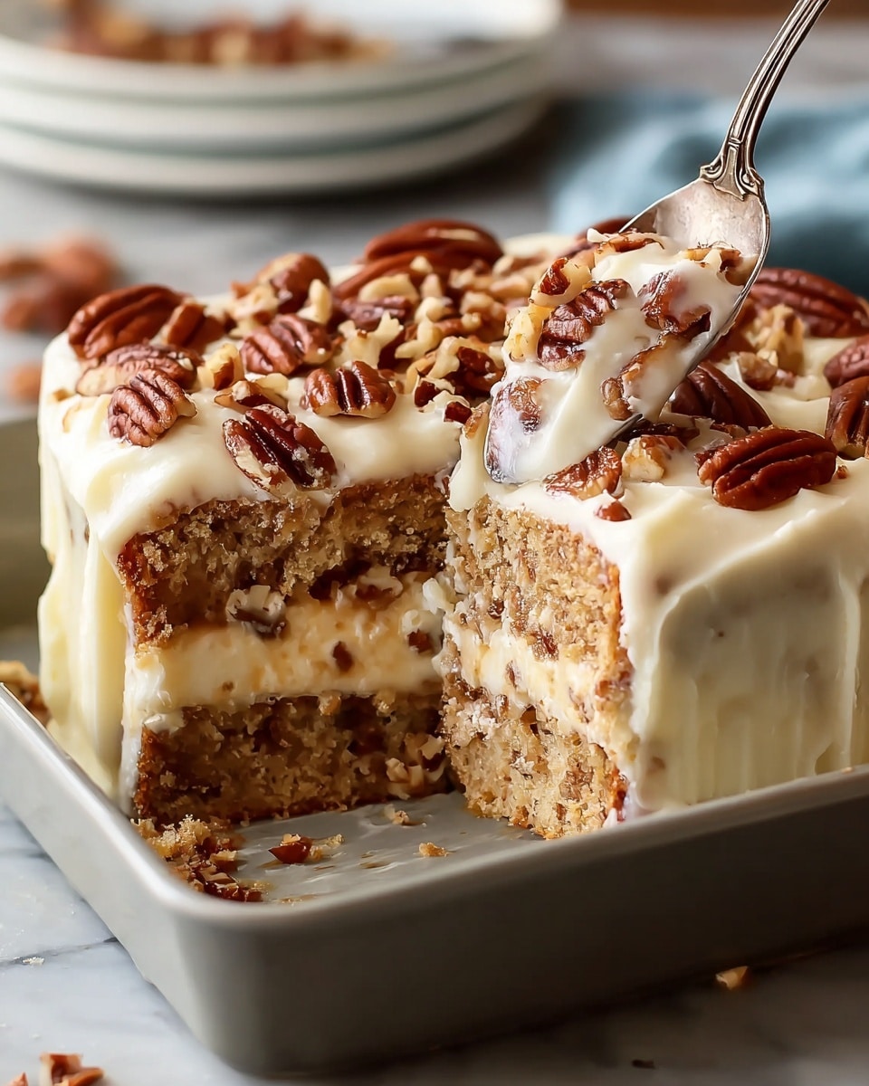 A square, three-layer cake is shown with a thick, creamy white frosting covering the top and sides. The top layer is decorated with whole and chopped brown pecans scattered evenly. Inside, the cake is light tan with visible textured layers of what looks like nuts or cinnamon filling. A spoon is cutting into the cake from the top right, revealing layers of soft cake and creamy frosting between them. The cake sits in a light gray baking dish, placed on a white marbled surface with a blurred background. photo taken with an iphone --ar 4:5 --v 7