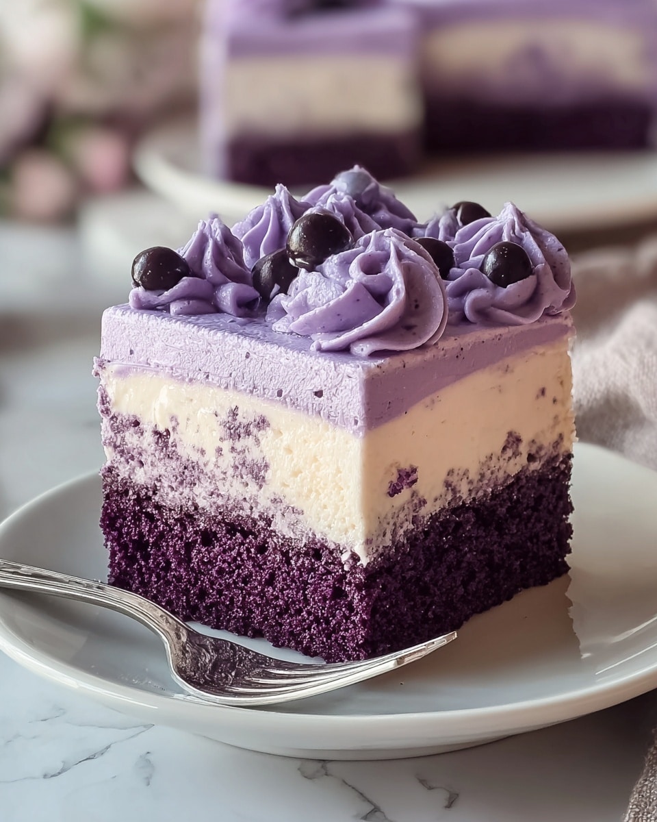 A square piece of three-layer cake sits on a white plate with a silver fork beside it. The bottom layer is a moist, deep purple cake, topped by a thick creamy off-white layer with small purple specks inside. The top layer is a smooth light purple frosting, decorated with small swirls of darker purple cream and tiny dark purple round toppings. The background features a blurred, larger portion of the same cake on a white plate over a white marbled surface. Photo taken with an iphone --ar 4:5 --v 7
